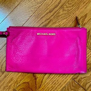 Fashionable Michael Kors fuchsia wristlet.